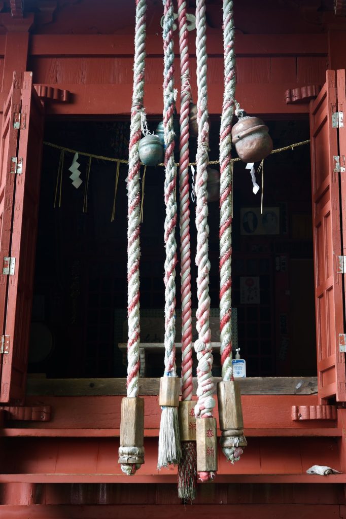Traditional ropes and bells in front of a temple.